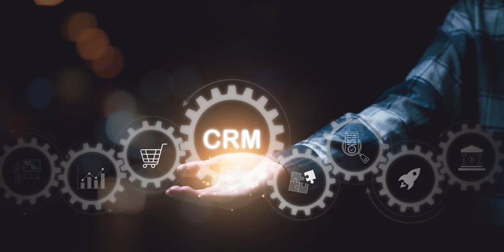 A hand outstretched with a cog showing CRM as the centre of their business