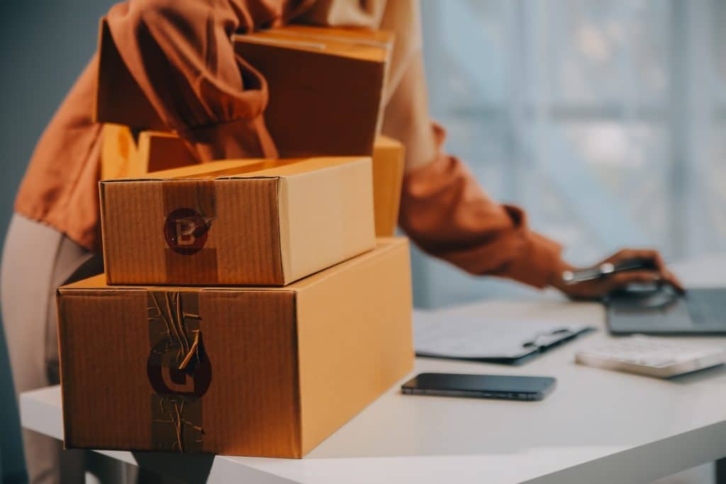 an eCommerce business owner, packaging up her orders and looking into how to ship to Amazon FBA