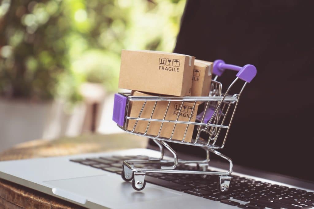 A mini shopping trolley with boxes in, on a laptop to represent ‘Top Selling Items on Amazon in 2024’.
