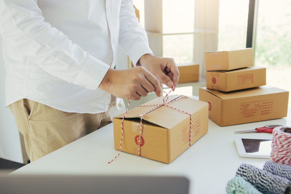 A small business owner packing subscription boxes to represent 9 Tips For Making a Subscription Business Model Work For You