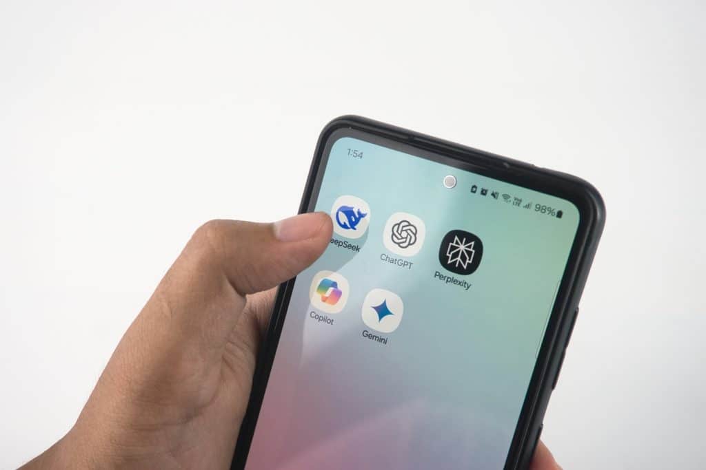 A person holding a phone with various AI apps to represent AI in eCommerce.